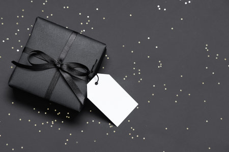 Gift box and confetti on dark background. Black Friday sale. Top viewの写真素材
