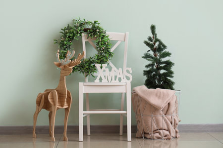 Chair, Christmas decor and mistletoe wreath near green wall in roomの写真素材