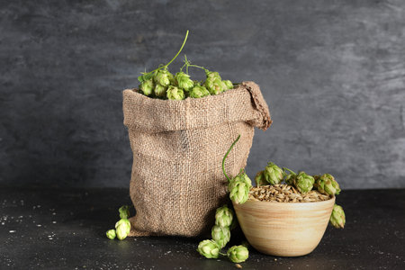 Bag with green hops cones on black background