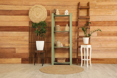 Stylish interior of living room with shelving unit, houseplant and folding screenの写真素材