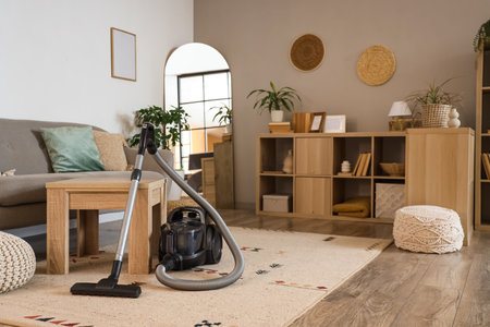 Interior of living room with vacuum cleaner, sofa and tableの写真素材