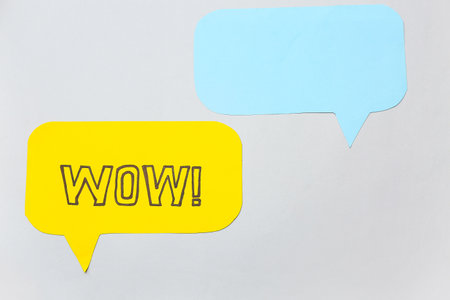 Paper speech bubbles with word WOW on gray backgroundの写真素材