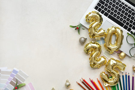 Figure 2025 with laptop, color palettes and Christmas balls on white background
