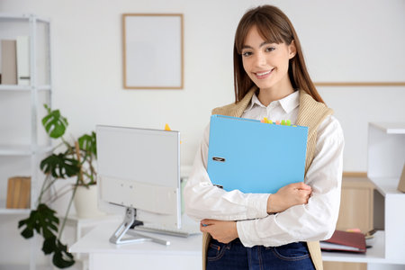 Young businesswoman with folder in officeの写真素材
