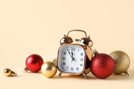 Beautiful composition with alarm clock and Christmas balls on beige backgroundの写真素材