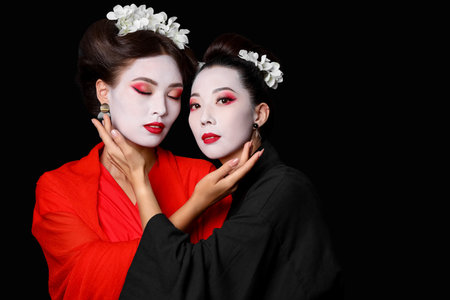 Beautiful young geishas on dark backgroundの写真素材