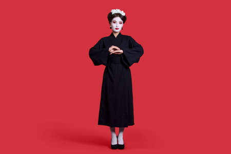 Beautiful young geisha on red backgroundの写真素材