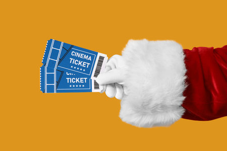 Santa's hand with cinema tickets on yellow backgroundの写真素材