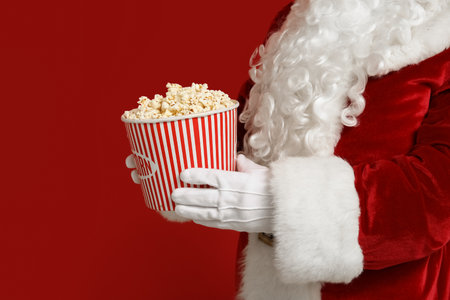 Santa Claus with bucket of popcorn on red background. Closeupの写真素材