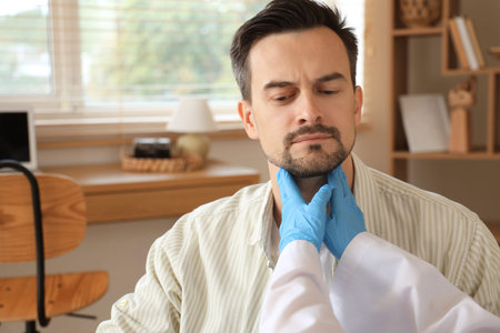 Female endocrinologist examining man's thyroid gland at home, closeup