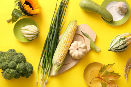 Wooden box with different fresh vegetables and sunflower on yellow background. Harvest festivalの写真素材