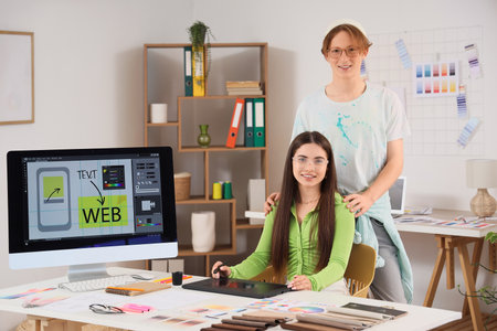 Young couple of graphic designers in officeの写真素材