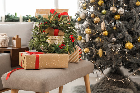 Mistletoe wreath on gift boxes near Christmas tree in living roomの写真素材