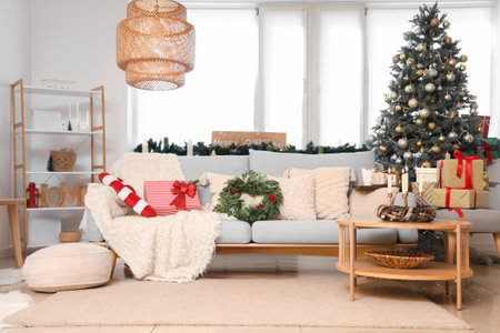 Cozy sofa with Christmas mistletoe wreath in decorated living roomの写真素材