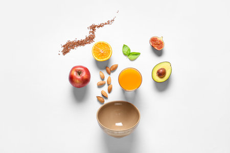 Tasty breakfast with chia seeds, fruits, almond nuts and juice on white backgroundの写真素材