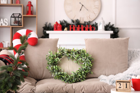 Cozy sofa with mistletoe wreath in Christmas interior of living roomの写真素材