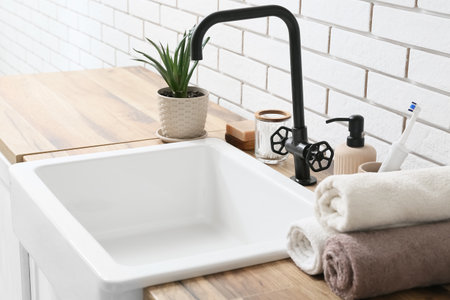 Bath accessories and houseplant near white brick wall in bathroomの写真素材