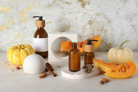 Bottles of cosmetic products with pumpkin, seeds, cinnamon and almond nuts on white backgroundの写真素材