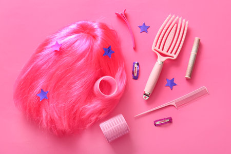 Composition with bright female wig and accessories on pink backgroundの写真素材