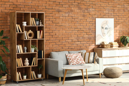 Cozy sofa, shelving unit and chest of drawers in interior of living roomの写真素材