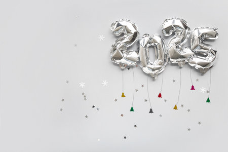 Figure 2025 made of foil balloons and confetti on gray backgroundの写真素材