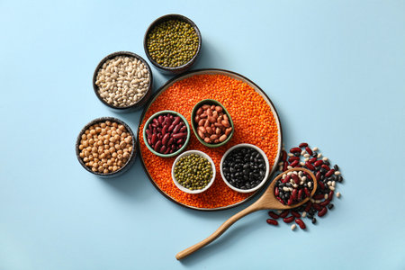 Composition with different raw legumes on color background