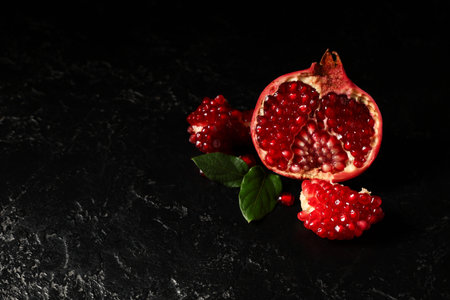 Pieces of tasty fresh pomegranate on black backgroundの写真素材