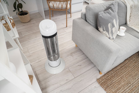 Electric heater near sofa in living roomの写真素材