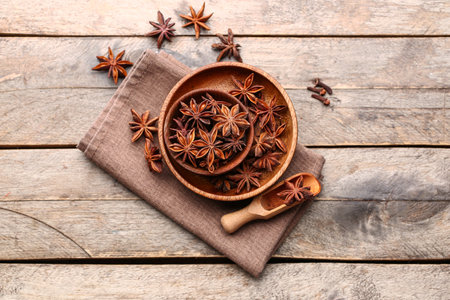 Bowls with aromatic star anise and napkin on wooden tableの写真素材