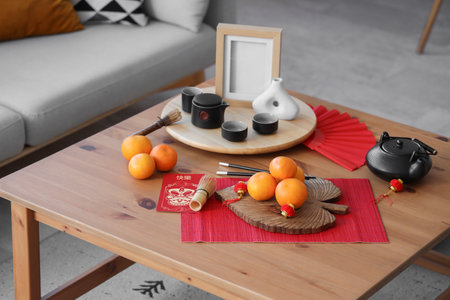 Mandarins with tea and Chinese New Year symbols on table in living roomの写真素材