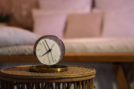 Golden alarm clock on table in bedroom at night, closeupの写真素材