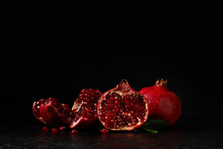 Pieces of ripe tasty pomegranate on black backgroundの写真素材