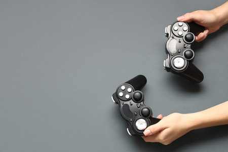 Female hands with modern game pads on dark background