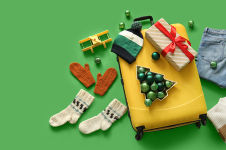 Suitcase, winter clothes and Christmas decor on green background. Top viewの写真素材