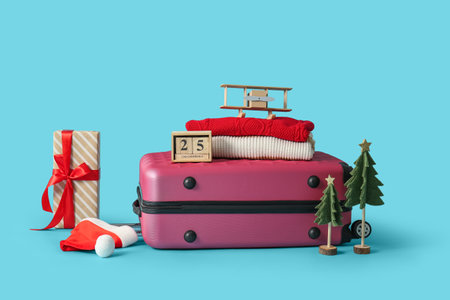 Suitcase, winter clothes and Christmas decor on blue backgroundの写真素材