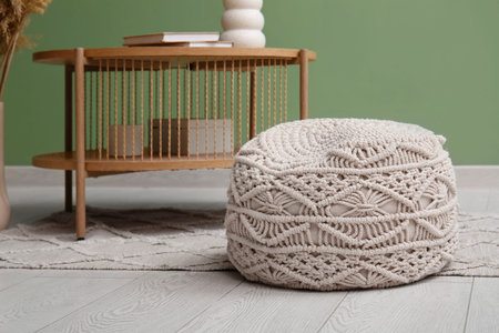 White knitted pouf and coffee table near green wall in room. Closeupの写真素材