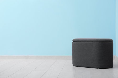 Black pouf near blue wall in roomの写真素材