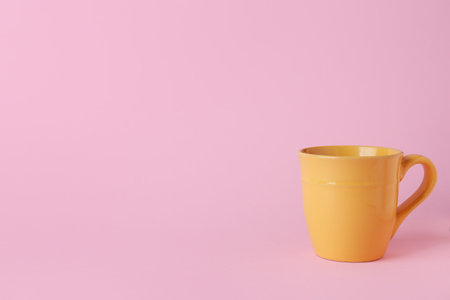 Yellow ceramic empty mug on pink backgroundの写真素材