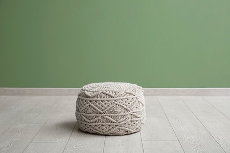 White knitted pouf near green wall in roomの写真素材
