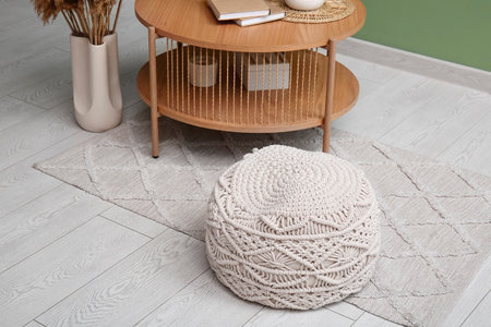 White knitted pouf and coffee table near green wall in roomの写真素材
