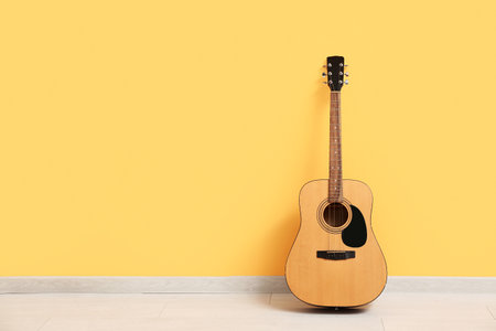 Acoustic guitar near color wall in roomの写真素材