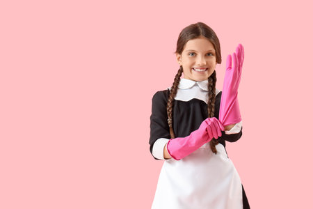 Cute chambermaid in rubber gloves on pink backgroundの写真素材