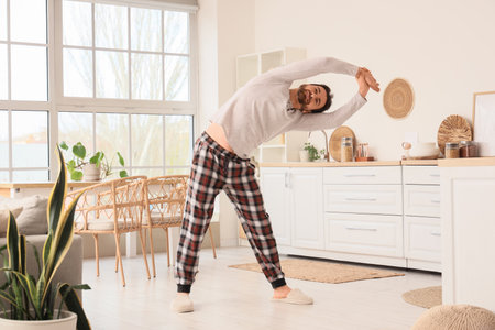 Morning of handsome man exercising in kitchenの写真素材