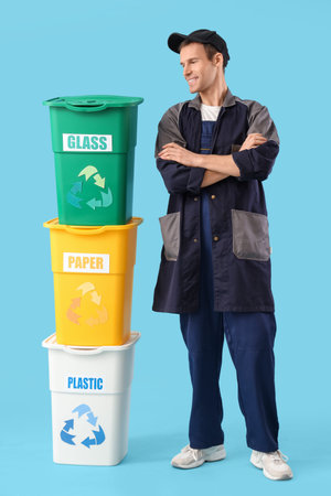 Male scavenger with trash bins on blue backgroundの写真素材