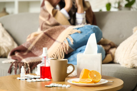Medicines with lemon on table against ill woman at home, closeupの写真素材