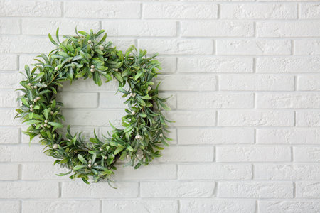 Christmas mistletoe wreath on white brick wallの写真素材