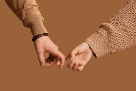 Couple holding hands on brown background