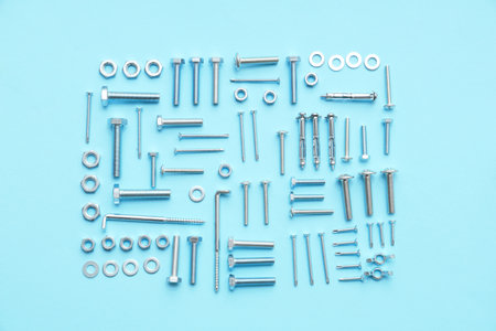 Arrangement of different tap bolts, chrome nuts and hex keys on blue backgroundの写真素材