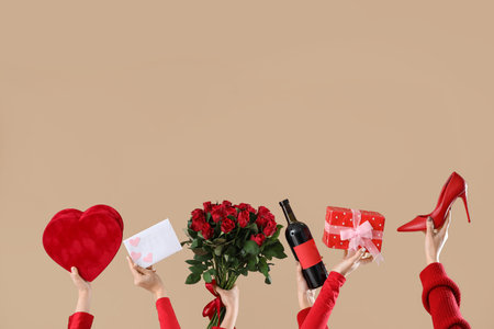 Female hands with gifts, wine, letter and high heel on beige background. Valentine's Day celebrationの写真素材