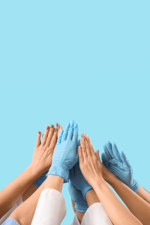 Group of doctors putting hands together on blue backgroundの写真素材